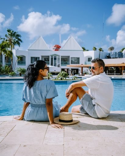 Luxury resort with swimming pool near Palm Beach Aruba Caribbean, couple man and woman mid age on a luxury vacation in the Caribbean