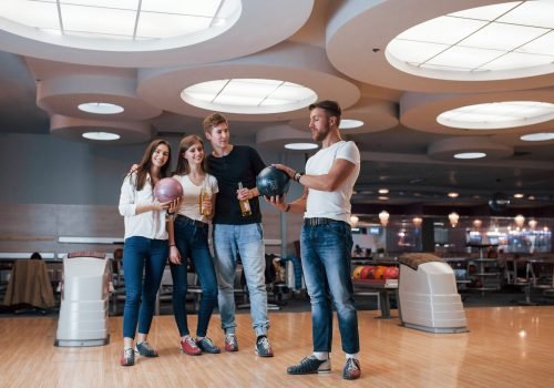 Guy talking about something. Young cheerful friends have fun in bowling club at their weekends Guy talking about something. Young cheerful friends have fun in bowling club at their weekends.
